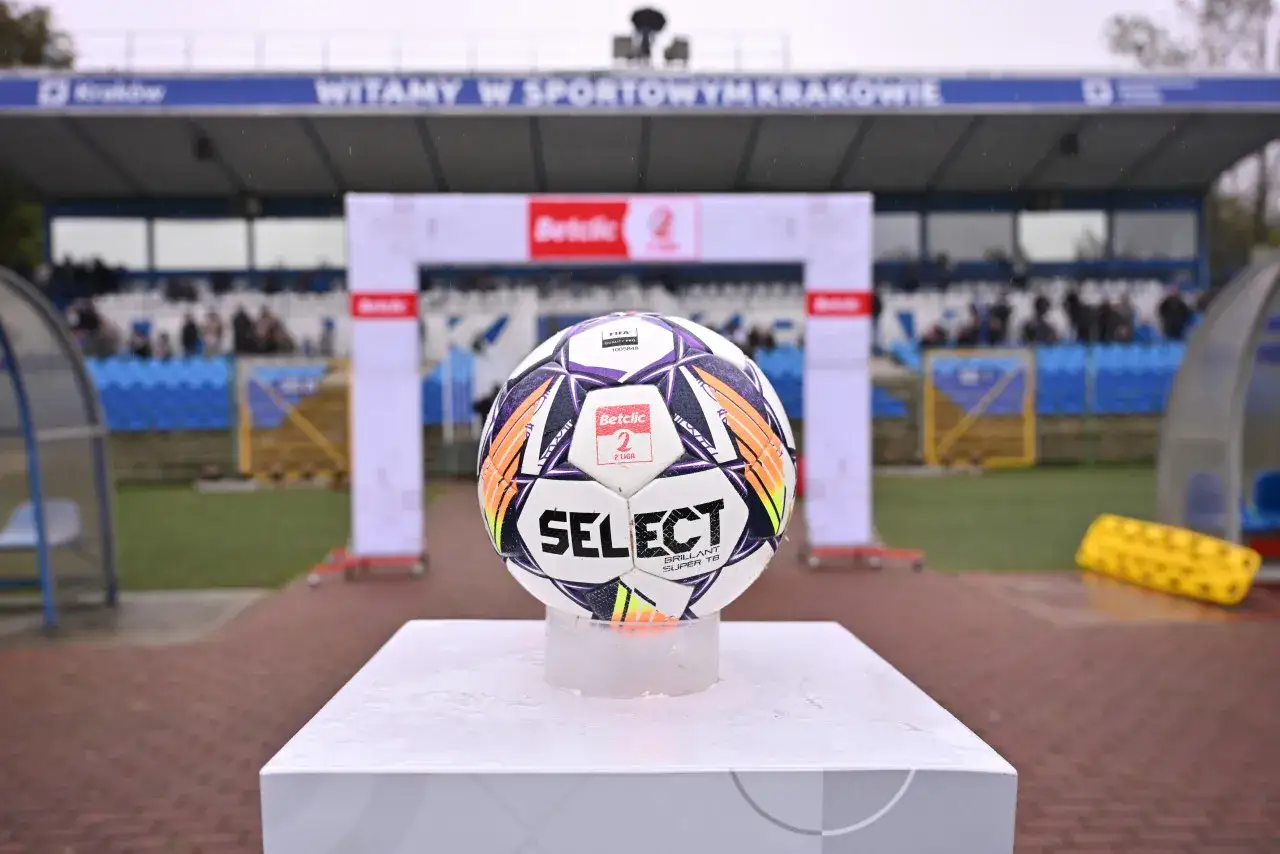 Piłka Select na tle stadionu. Zastanawiasz się, ile drużyn awansuje z 2 ligi do 1. ligi?