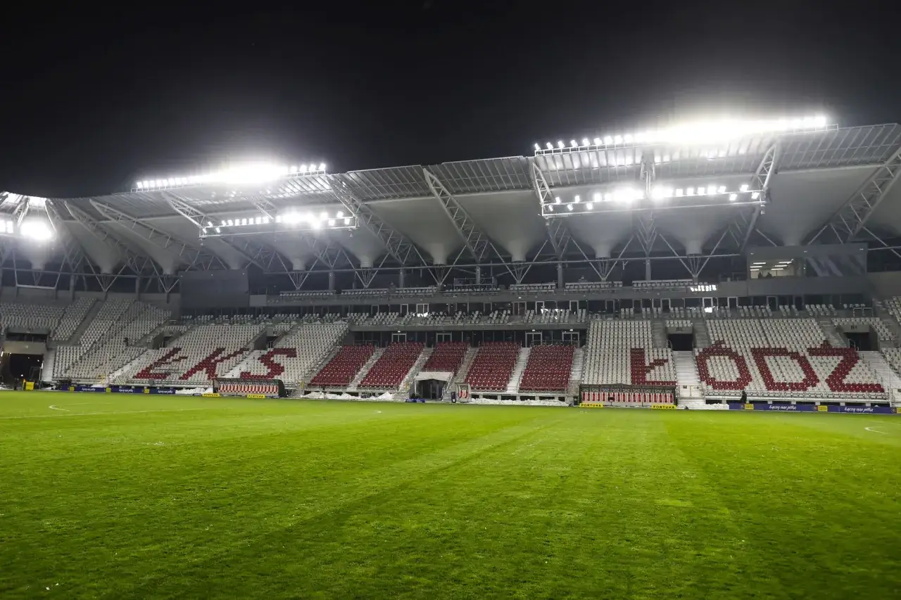 Stadion z podświetlanymi trybunami, na kt&oacute;rych widnieje napis 