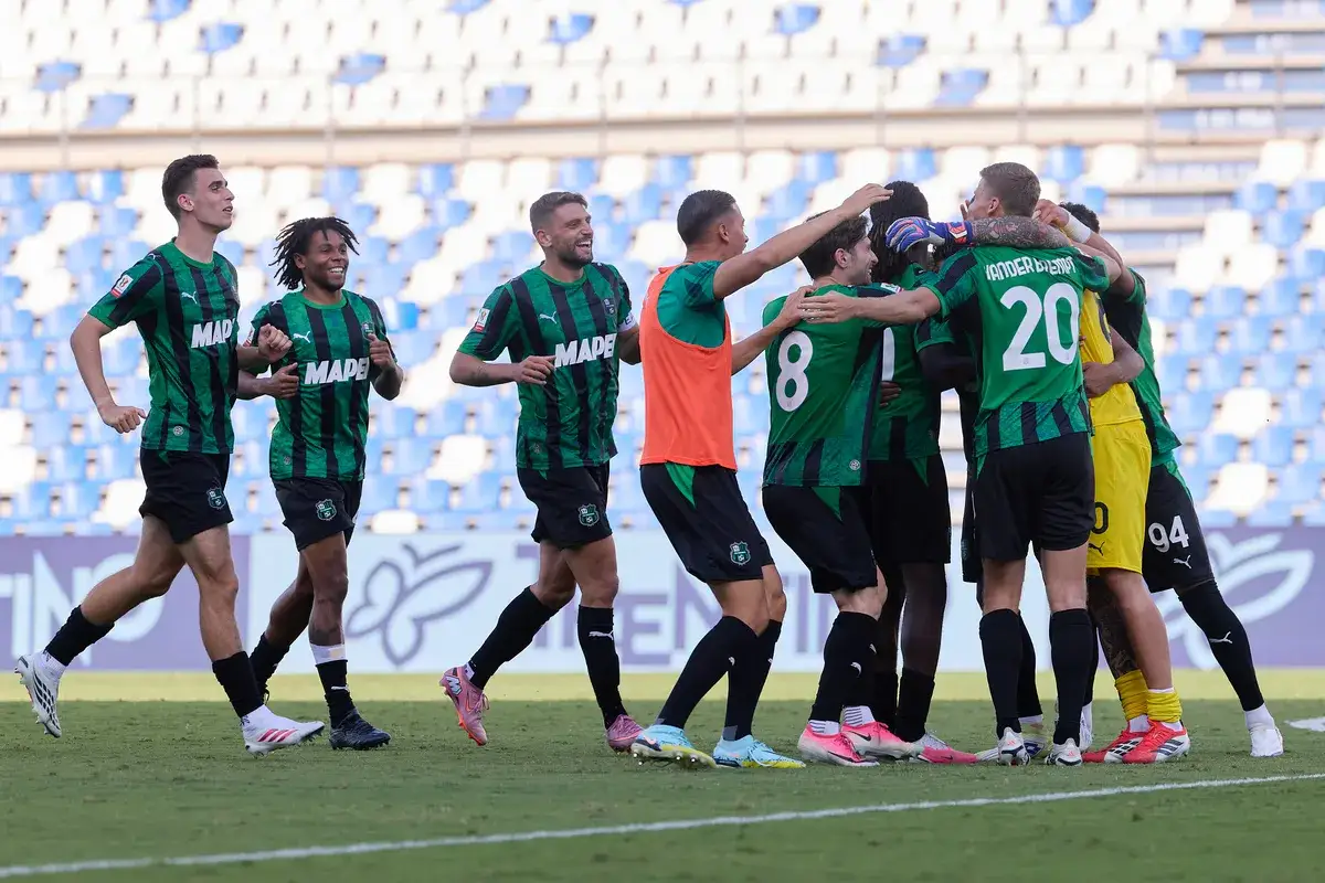 Piłkarze Sassuolo świętują bramkę podczas rozgrywek. Drużyna w zielono-czarnych strojach cieszy się ze zwycięstwa na boisku.
