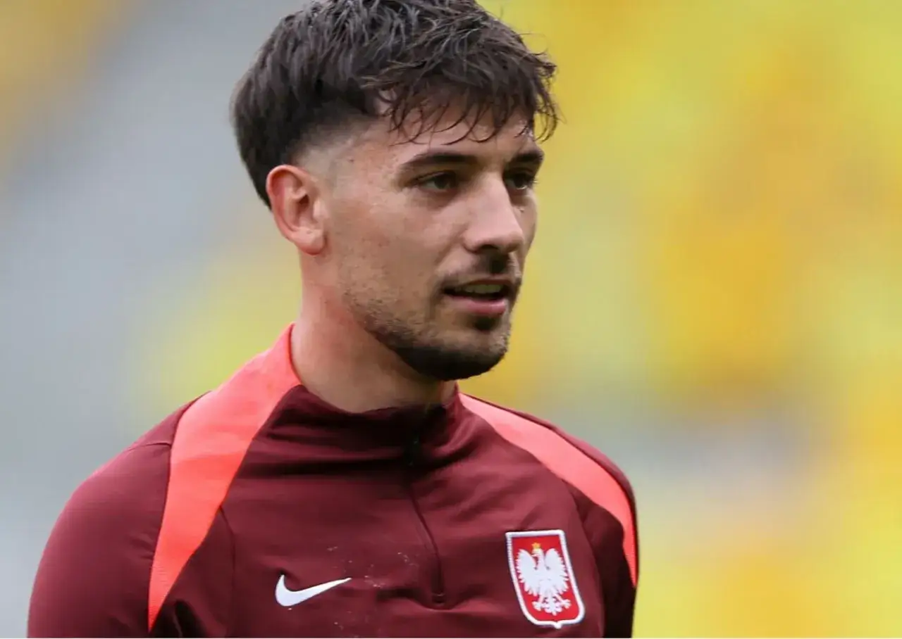 Kuba Moder w bordowej koszulce z godłem Polski, gotowy do gry.
