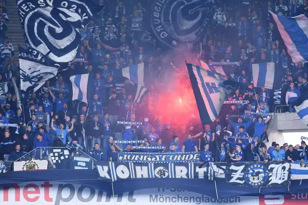 Tłum kibiców MSV Duisburg z flagami i racami.