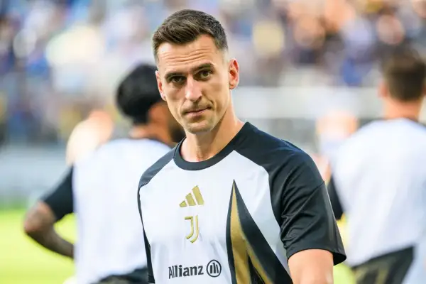 Juventus – zawodnicy. Skupiony piłkarz w koszulce z logo klubu i sponsorem Allianz, gotowy do gry.