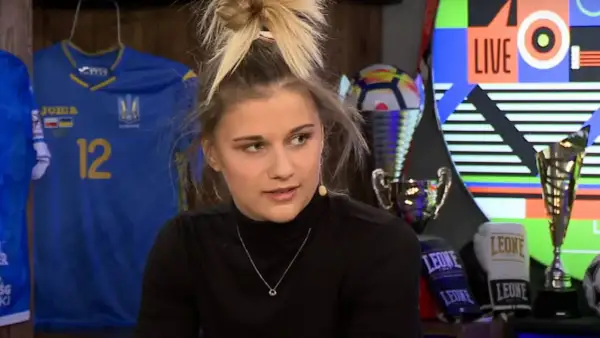 Oliwia Szperkowska w czarnym golfie, z piłkarską koszulką Ukrainy i trofeami w tle.