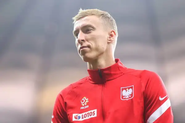 Adam Buksa w czerwonej bluzie reprezentacji Polski, z orłem na piersi.