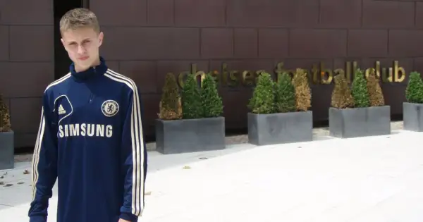 Młody Hubert Adamczyk w dresie Chelsea przed klubem.
