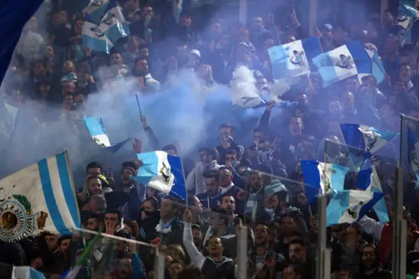 Tłum kibiców Lazio Rzym świętuje, machając flagami i odpalając race.