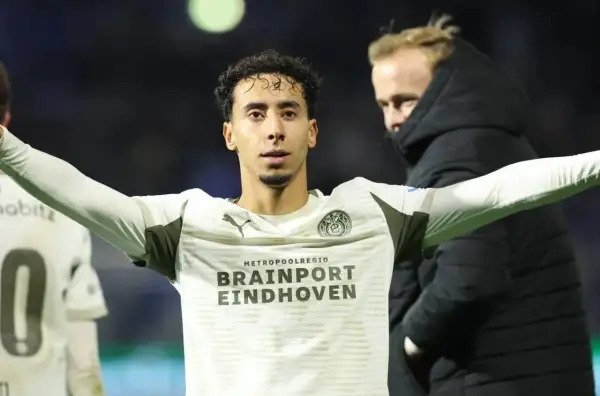 Jerdy Schouten w białej koszulce z logo PSV Eindhoven, z rękami rozłożonymi na boki.