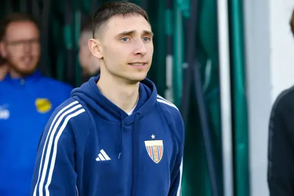 Jakub Arak w granatowej bluzie z herbem Polonii Bytom, gotowy do wyjścia na boisko.