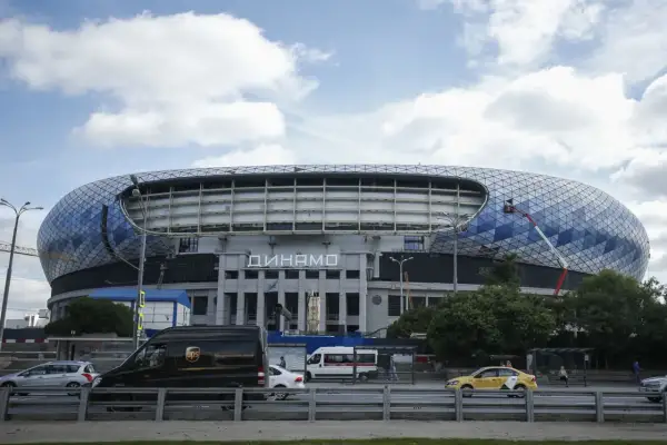 Nowoczesny stadion Dynamo Mińsk z charakterystyczną, geometryczną fasadą. Na dachu widać pracownika na wysięgniku.